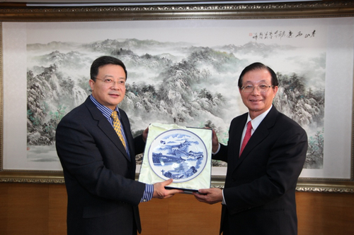 图为贾勇副理事长向吴清基总校长赠送纪念品