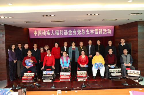 图为基金会领导和任士荣老师及盲人乐队合影