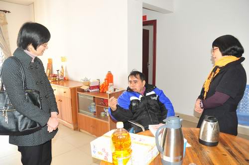 区府办副调研员李康华（左一）与我会理事长黎倩玲（右一）对谷围新村贫困残疾人进行慰问