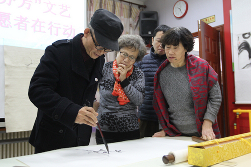 图为文艺志愿者辅导残疾人绘画