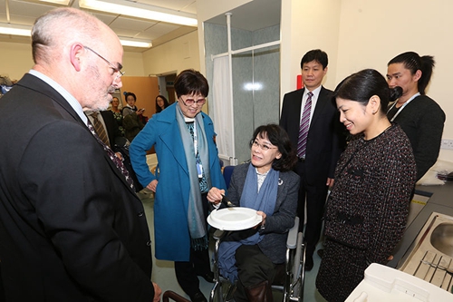 图为张海迪主席深入考察医院的生活能力训练室，详细询问设计理念和使用情况
