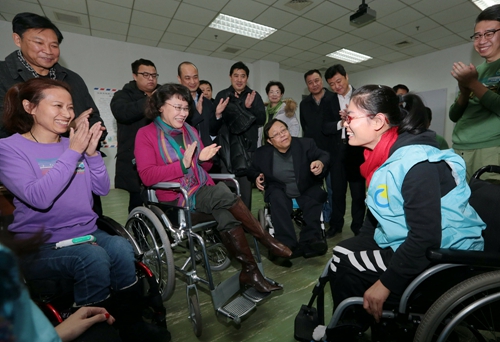 图为海迪主席调研脊髓损伤学员康复训练情况，这是学员在进行轮椅使用训练