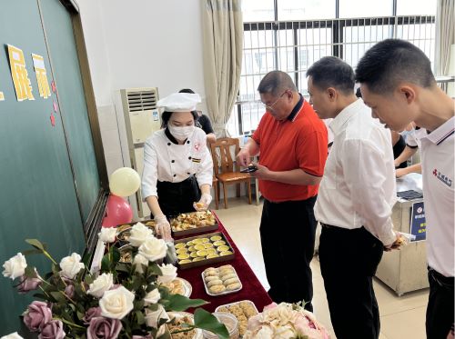 区残联郑月利副理事长（右二）了解残疾学生糕点制作课程